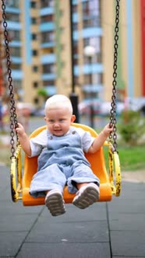 Adorable Infant Enjoying a Swing at the Playground