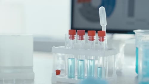 Gloved Hand Placing Test Tube in Lab Rack