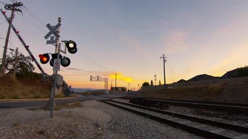 As luzes de um portão de travessia ferroviária piscam quando ele se abre após a passagem de um trem e permite que os carros sigam até