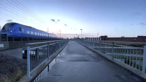 auf einer Brücke laufen, während der Zug vorbeifährt