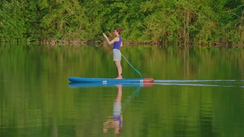 Alone Woman Floating on Stand Up Paddle Board in Lake in Summertime Standup Paddleboarding Surfer