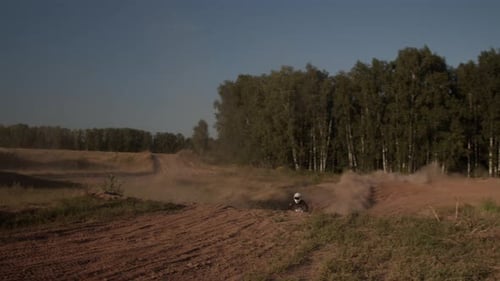 Extreme Sportsman Rides Motorcycle Jumping on Hills on Field