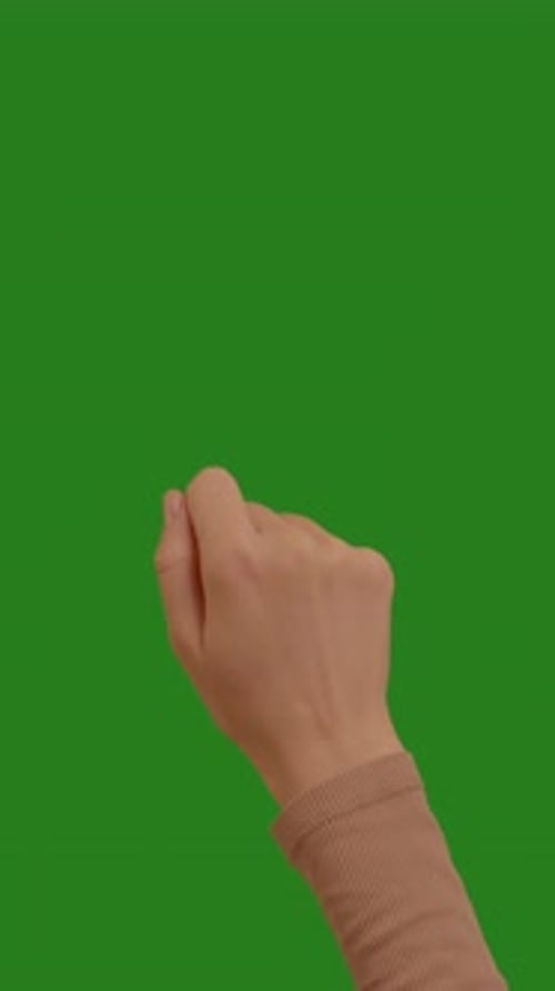 Young woman knocks on the green screen background with her hand.