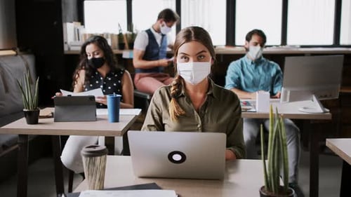 Portrait of Young Businesspeople with Face Masks Working Indoors in Office