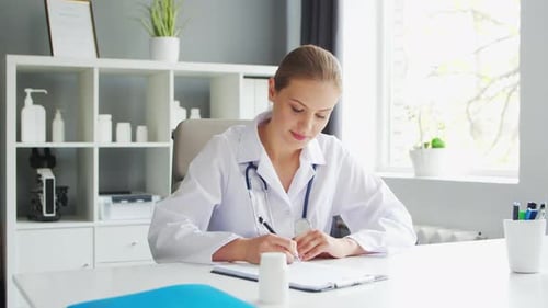Doctor Works in the Medical Office Woman in White Coat Workplace of a Professional Female Therapist