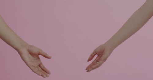 Hands Make Heart Shape Together on Pink Background