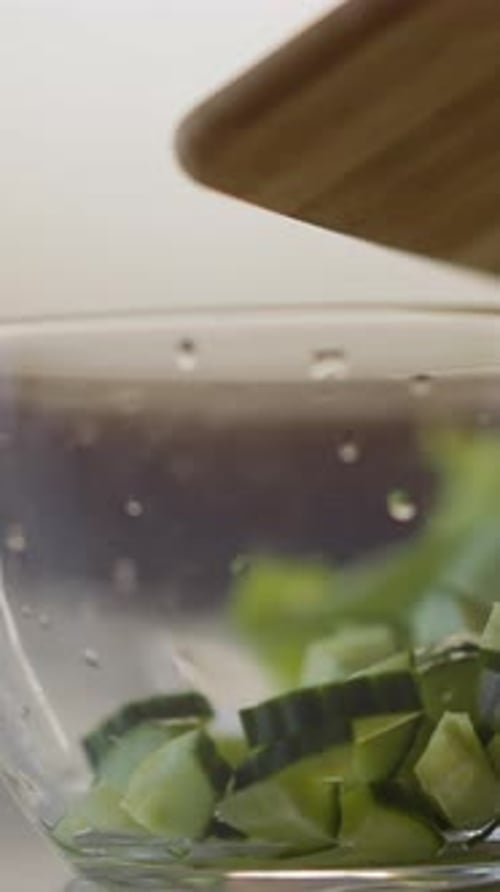 Diced Cucumber Pieces Falling Into Glass Bowl