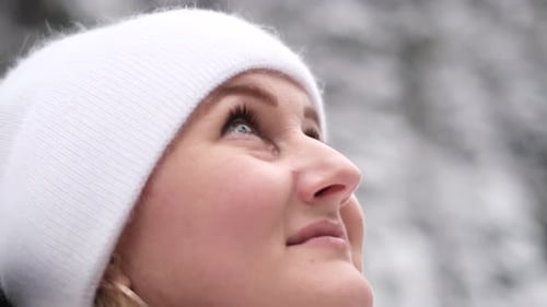 Portrait of a Young Woman in a White Hat in the Middle of a Winter Forest
