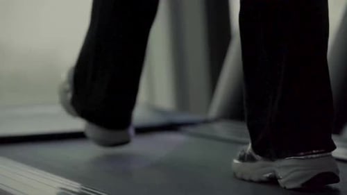 female sneakers walking on treadmill in gym