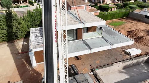 Modules of prefabricated modular building. Aerial drone orbiting around crane