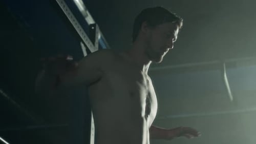 Young Man Warming up Chest and Arms while Training at Gym