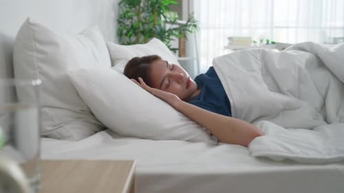 Young Woman Sleeping Peacefully in Bed at Home