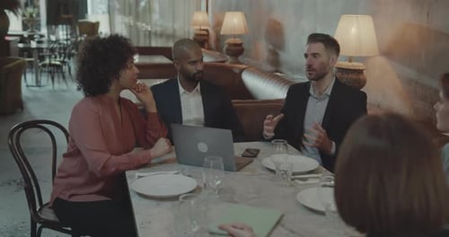 Businesspeople having an off-site Meeting in Restaurant using Laptop