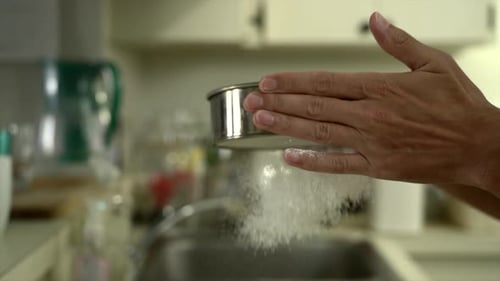 Hands Sifting Flour in Kitchen Setting