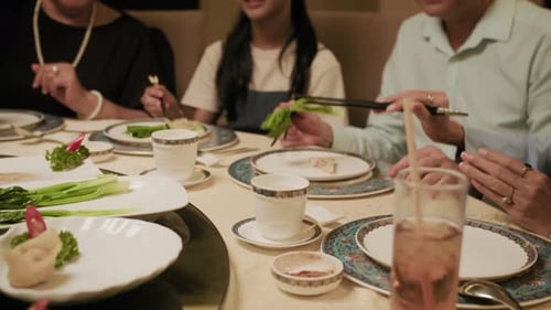 Asian Family Enjoying Dinner Together in Restaurant
