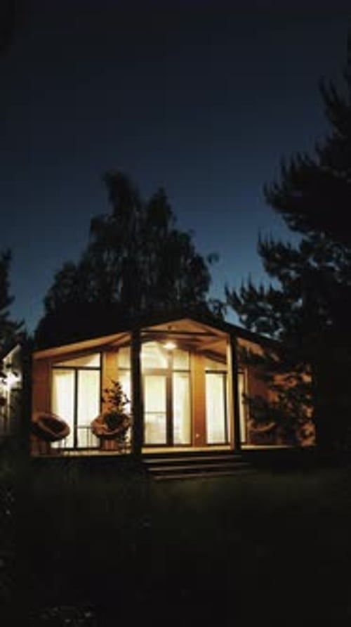 Illuminated Cabin at Night in Nature Setting