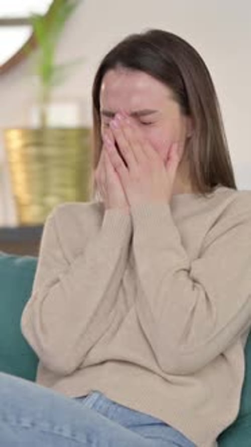 Distraught Woman Crying on Couch in Home Interior