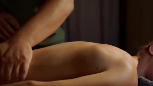 Men's Hands Crumple the Girl's Back Against the Background of Warm Candles Wellness Treatments Spa