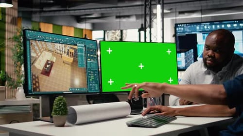 Real Estate Colleagues Evaluates Blueprints Next to Chroma Key Screen
