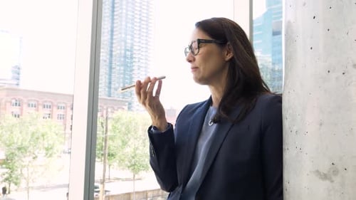 Businesswoman in Suit Talking on Smart Phone in Urban Office Adult