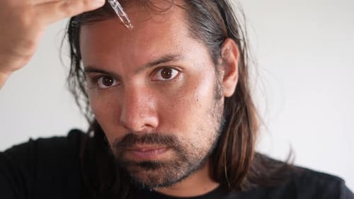 Man Applies Hair Serum with Dropper, Close Up