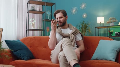 Bearded Man Speaking into Phone on Couch