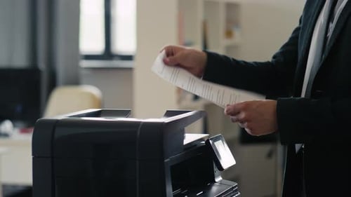 Man scanning documents into printer at the office