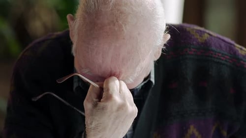 Senior Man Rubs Eyes, Looks Tired