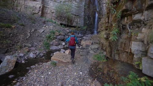 The hiking girl and waterfall in the forest․