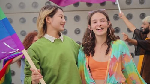 Two Women at a Pride Parade With Rainbow Flag