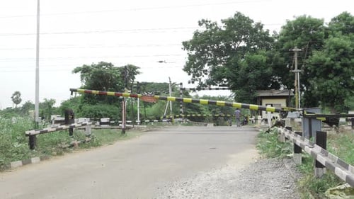 Rural Road Crossing with Gate and Distant Man