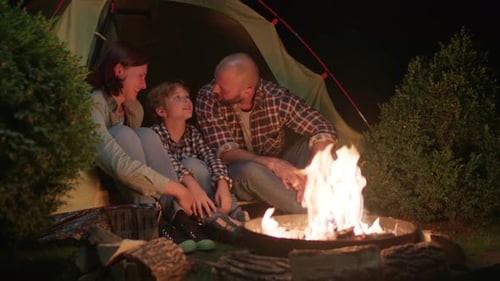 Family Talking Sitting in Tent By Campfire at Night Evening Camping Fire Talk Mom Dad and Kid