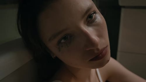 Close-up of Depressed Young Woman with Running Makeup Crying in Bathroom