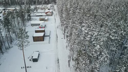 Aerial View of a Picturesque Winter Wonderland Featuring Stunning Snow Covered Cabins Nestled in a
