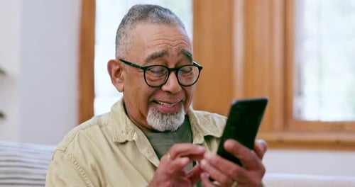 Senior Man Uses Mobile Phone Indoors