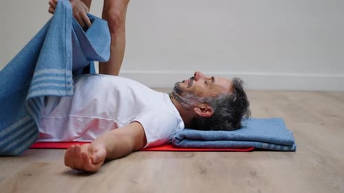 Man practicing twisting pose in green garden with calm focus
