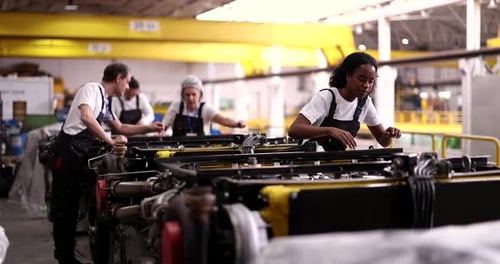 Groupe multiculturel de travailleurs industriels masculins et féminins collaborant à un assemblage de fabrication
