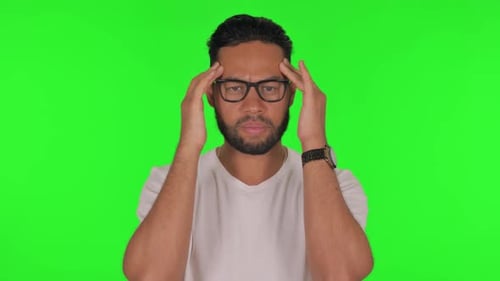 Man with Headache on Green Background