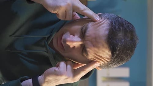 Man Rubs Temples During a Headache