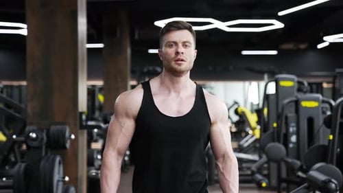 Belo atleta caminha no centro de fitness.