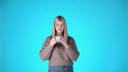 Young Woman Drinking Tea in Studio Setting