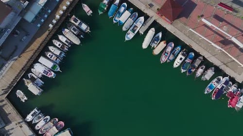 Luftbild Video Fischerbooten, die in einem Hafen mit ruhigem blauem Wasser und klarem Himmel angedockt sind, aufgenommen von