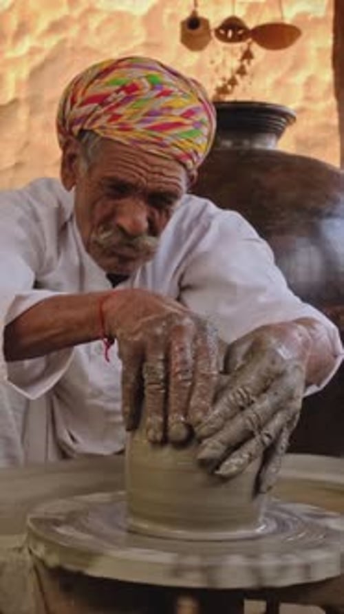Potier indien lançant un tour de potier et façonnant un pot en argile dans un atelier de poterie en Inde