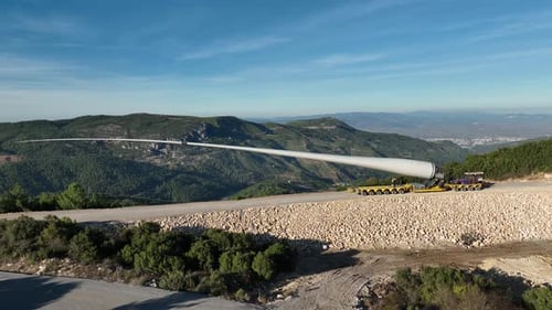 Aerial View Of Wind Turbine Blade Being Moved Through Mountains
