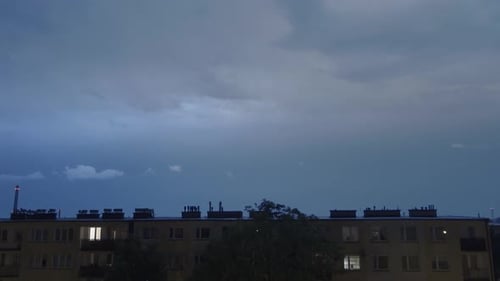 Handheld shot of powerful lightning strikes over the buildings in the middle of the city.