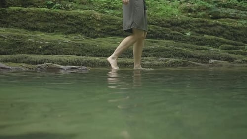 Mann geht auf dem Wasser mit felsiger Landschaft im Wald Kreative Frau geht auf dem Wasser im natürlichen Teich in