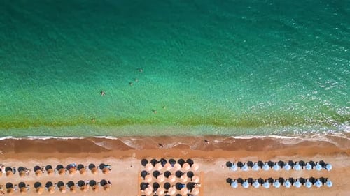 Topdown View of Sandy Beach with Sun Umbrellas and Turquoise Sea Water