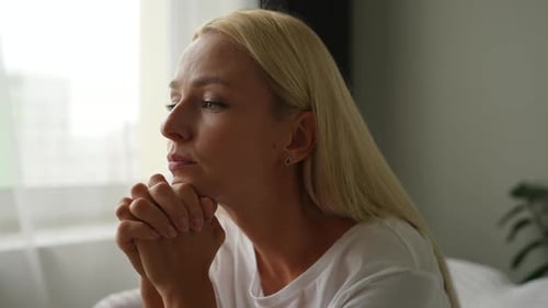 Pensive Woman with Hands Together, Looking Away