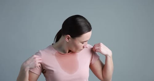 Femme souffrant de transpiration sur fond gris