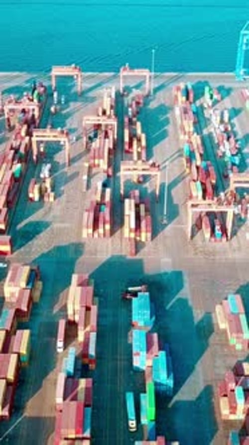Vidéo verticale du port - Images filmées par drone de conteneurs, de cargos et de grues de chargement dans le port